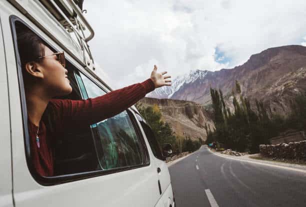 Woman enjoying the cool breeze from the car window